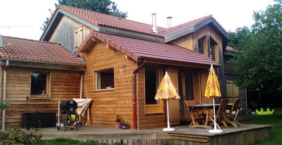 Construction maison en bois avec couverture en terre cuite, chenaux, et chapeaux de cheminée à Dardilly